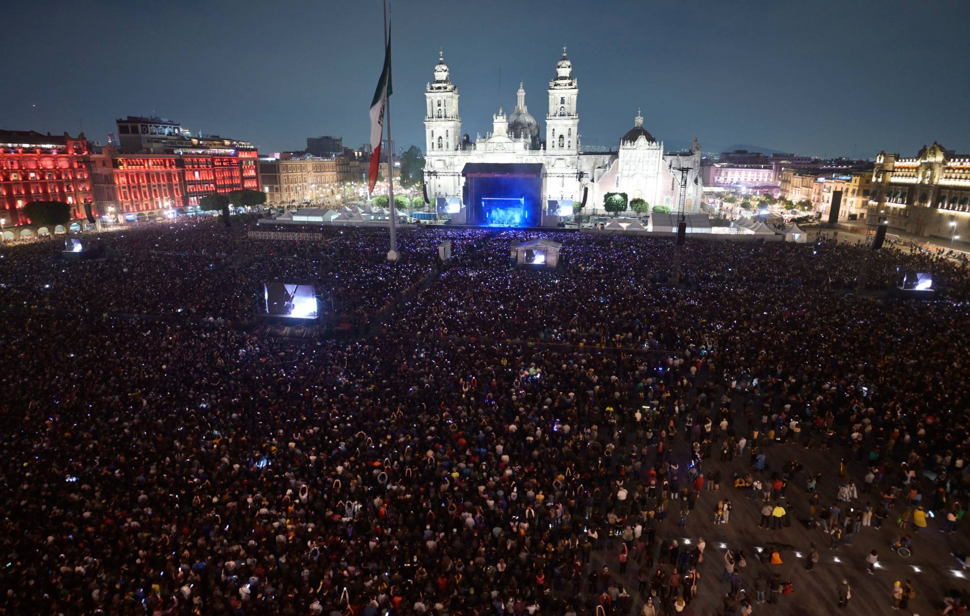 People gather to listen to American rock band Interpol perform at Zocalo Square in Mexico City on April 20, 2024. (Photo by ALFREDO ESTRELLA/AFP) (Photo by ALFREDO ESTRELLA/AFP via Getty Images)