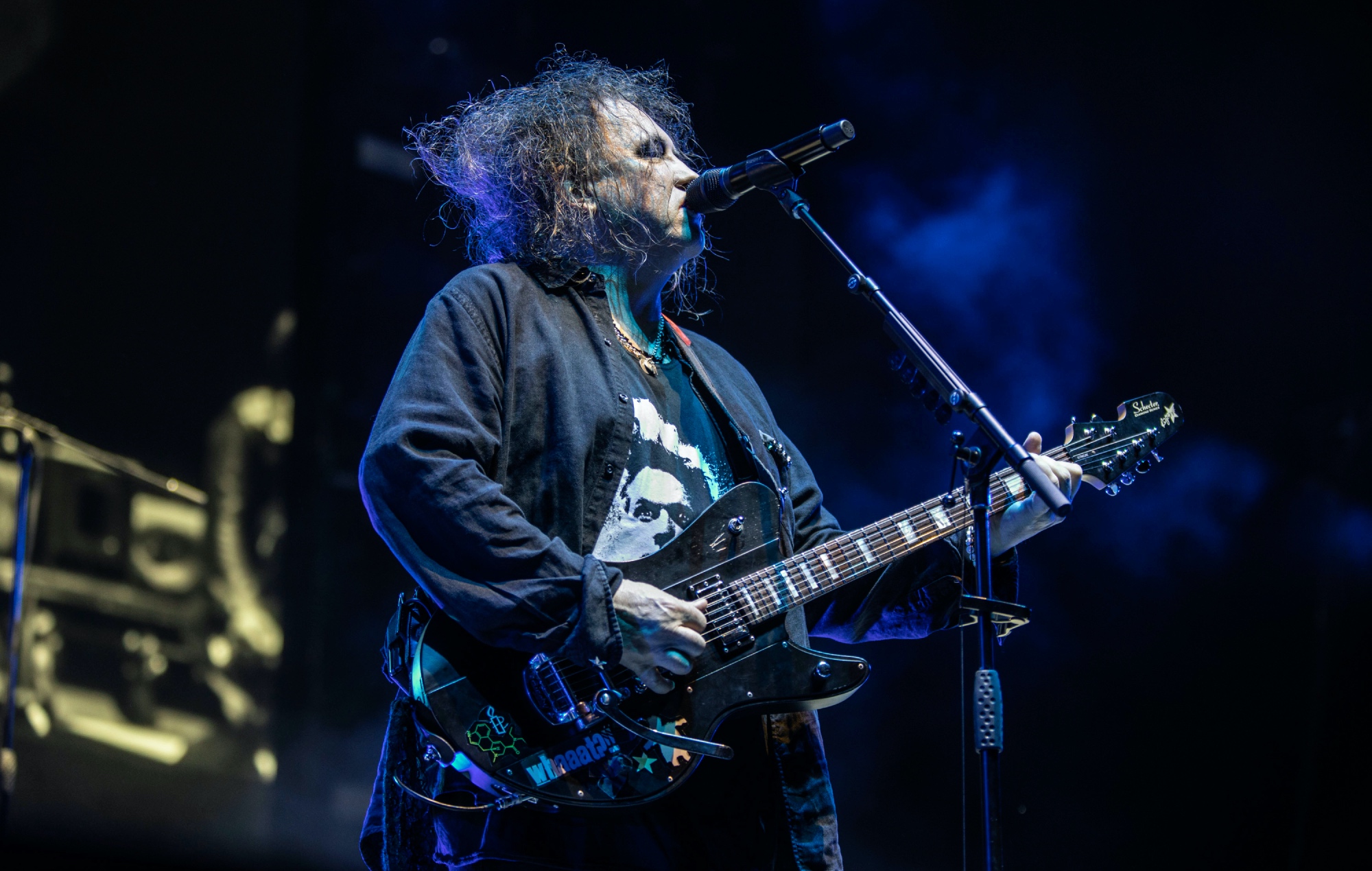 Robert Smith performs on stage with The Cure