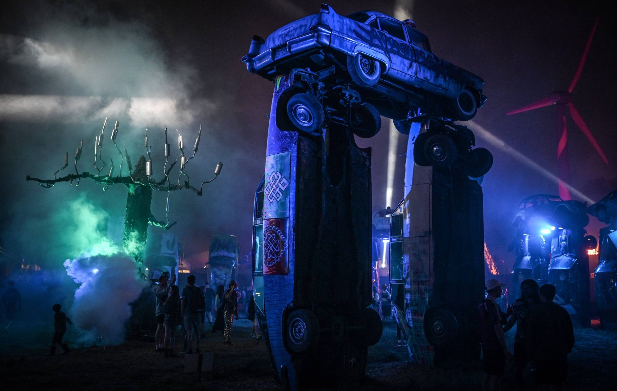 installation called "Carhenge" as a reference to Stonehenge on the first day of the Glastonbury festival. (Photo by OLI SCARFF/AFP via Getty Images)