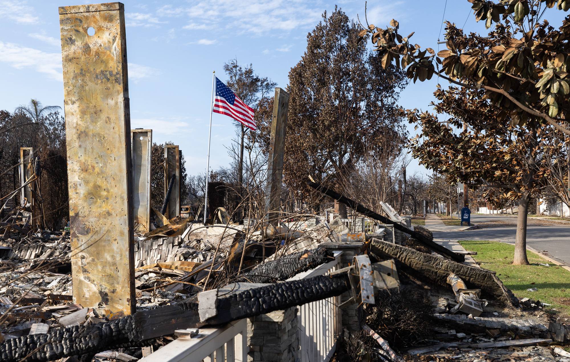 The flag flies in a destroyed house on Galloway-Sheve in the Pacific Palisades, California (Myung J. Chun / Los Angeles Times through Getty Images)