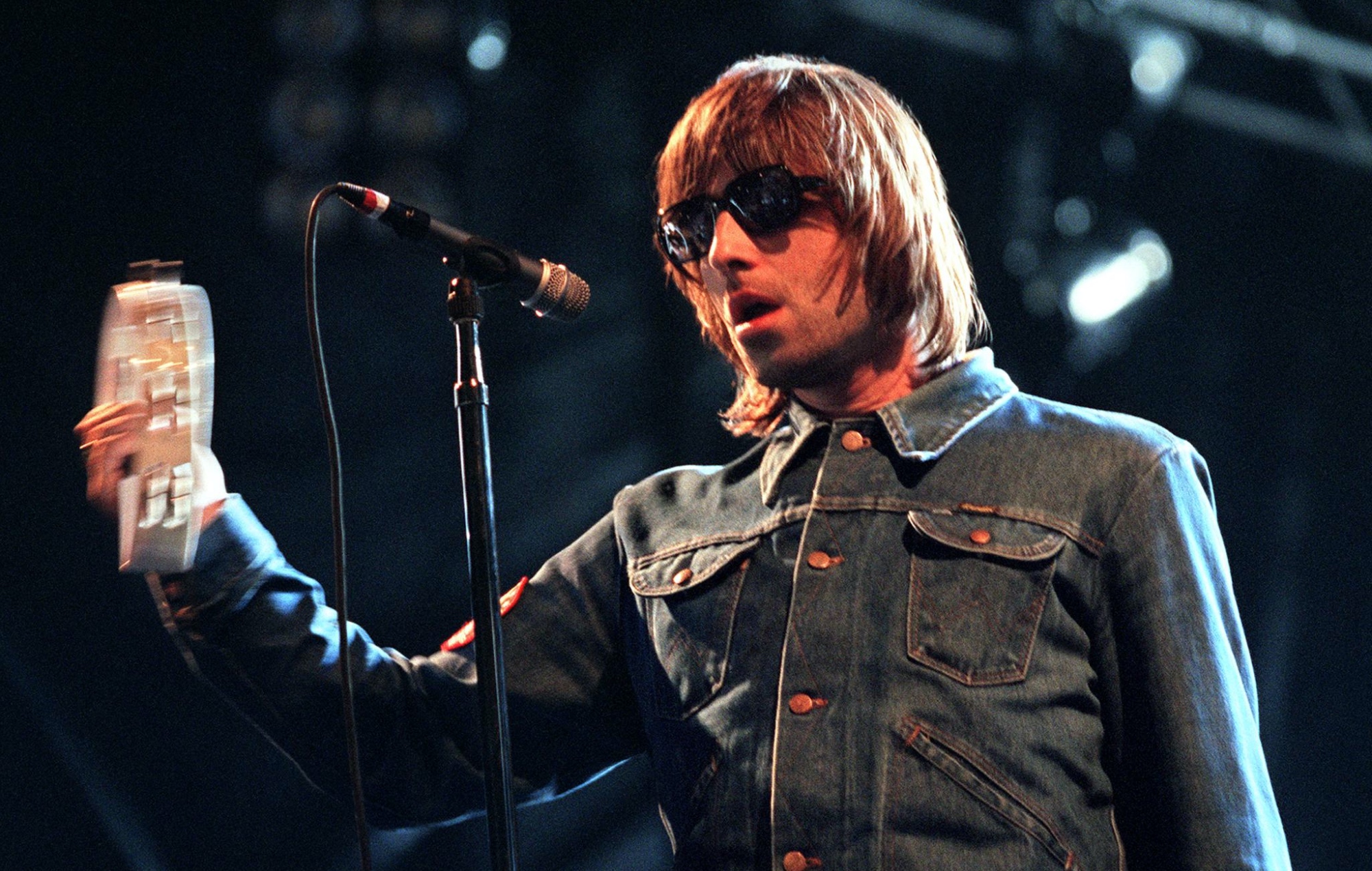 Liam Gallagher performs live on stage with Oasis in 2000